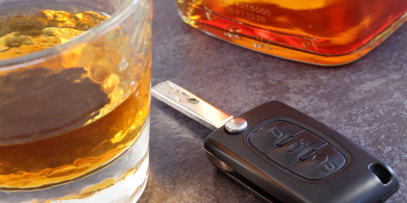 Photographie en gros plan de deux verres d'alcool entre lesquels est posée une clé de voiture